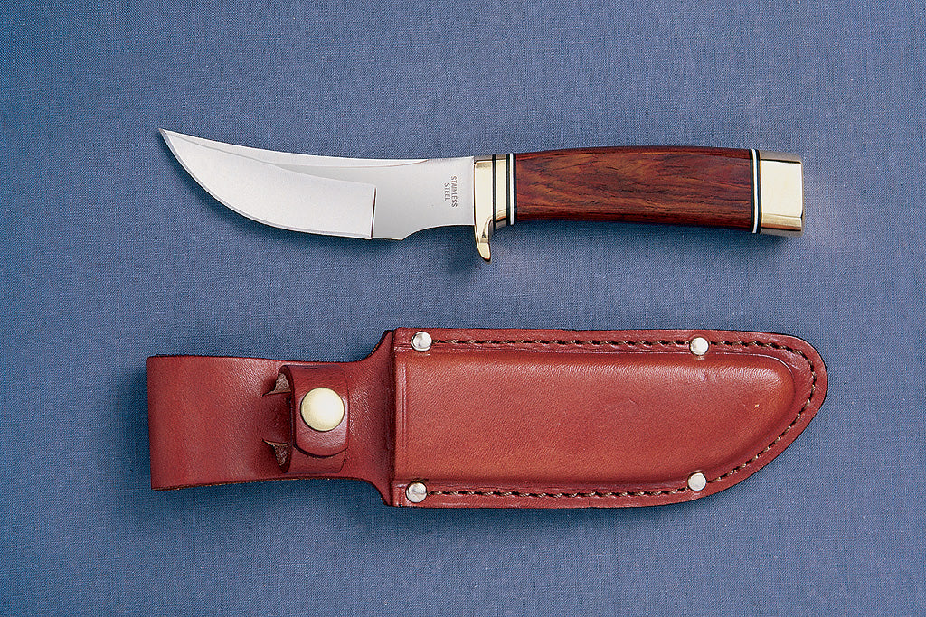 A Grohmann hunting knife with a curved blade and a brown leather sheath, displayed against a blue background.